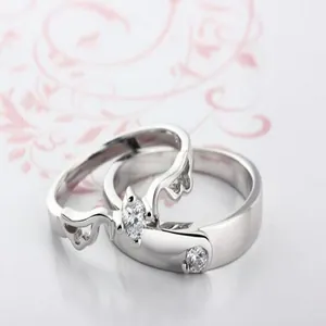 Detail view of silver-plated crystal couple rings with an elegant angel wing design