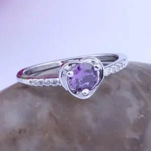 Detailed macro view of a heart-shaped purple AAA zircon ring with silver-tone setting