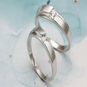 Close-up of elegant zirconia couple rings with polished silver-tone finish for wedding