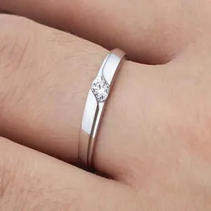Close-up detail of a classic silver band ring with a sparkling central zircon stone.