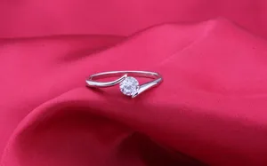 Elegant crossover silver ring with a sparkling round-cut cubic zirconia stone for women
