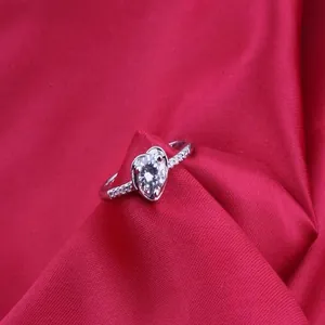 Macro view of heart-shaped AAA cubic zirconia ring set on a vibrant red fabric background