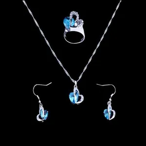 Blue heart-shaped crystal jewelry set including necklace, ring, and earrings on black background