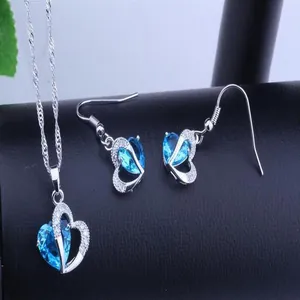 Detailed macro view of blue heart-shaped pendant necklace and matching drop earrings