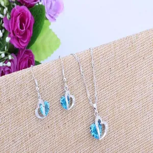 Detailed close-up of a silver heart-shaped jewelry set featuring vibrant blue ocean heart crystals