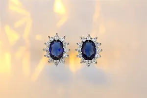 Detailed macro shot of oval blue sapphire stud earrings with zircon halo