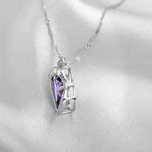 Side detail view of heart-shaped pendant featuring purple zircon and twisted silver chain