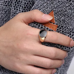 Detail view of a men's classic gold-plated ring featuring a sleek black enamel square center