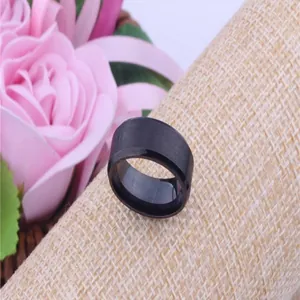 Close-up macro detail of 8mm black brushed stainless steel ring on textured background