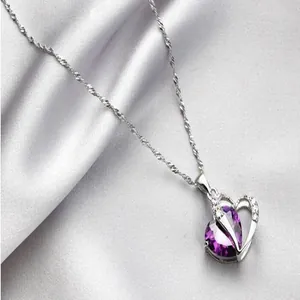 Detailed close-up of a heart-shaped necklace with a sparkling purple zircon pendant
