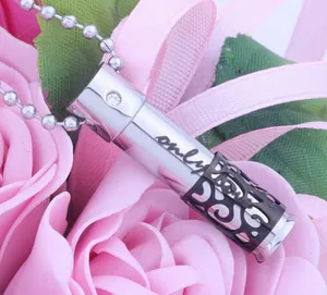 Detail of stainless steel perfume bottle pendant with "only" engraving on pink roses.