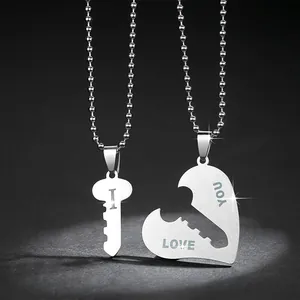 Primo piano collane coppia puzzle cuore e chiave in acciaio con incisione I LOVE YOU