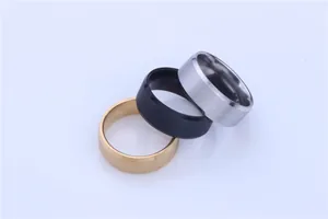 Macro detail of three 8mm brushed stainless steel rings in gold, black and silver.