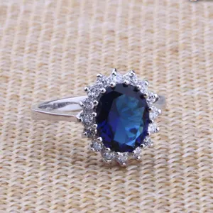 Detailed close-up view of a royal style oval blue sapphire and white zircon cluster ring.