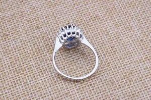 Macro detail of a silver sapphire halo ring featuring elegant zircon side stones