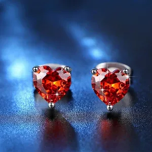 Elegant AAA heart-shaped red zircon stud earrings with silver finish on blue background