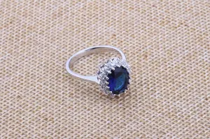 Elegant detail view of oval blue sapphire ring surrounded by a sparkling zircon halo