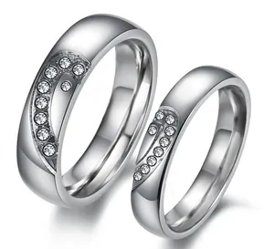 Gros plan détaillé de bagues de couple en acier titane argent avec motif cœur en strass