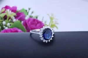 Detailed close-up of an elegant oval sapphire blue ring with a brilliant zircon halo setting