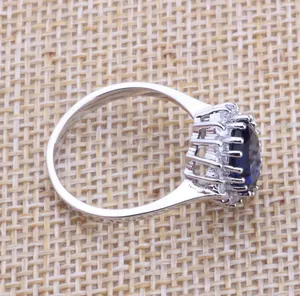 Side view detail of silver sapphire cluster ring featuring intricate basket setting structure