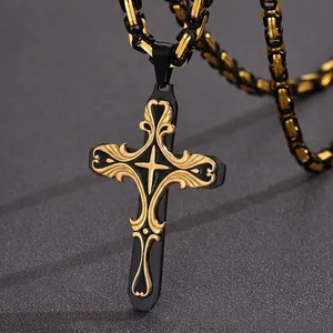 Close-up of black and gold stainless steel cross pendant with intricate floral pattern