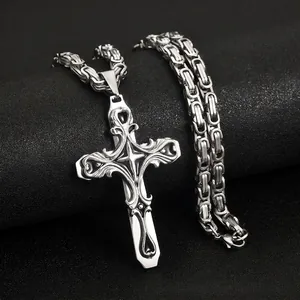Close-up view of vintage silver stainless steel cross pendant with detailed engraving
