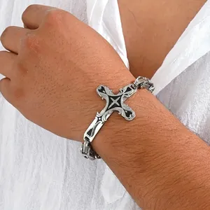 Macro view of vintage stainless steel cross bracelet with black enamel on male wrist