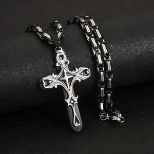 Detailed macro view of an ornate silver cross pendant with a bicolor Byzantine chain