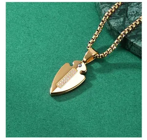 Detailed view of gold-plated spearhead pendant with rows of sparkling crystals