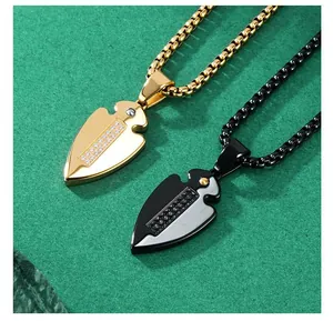 Macro detail of gold and black spearhead pendants with inlaid stones