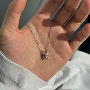 Vue détaillée d'un pendentif en moissanite ronde étincelante sur une chaîne en argent