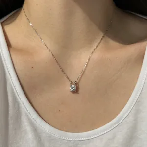 Gros plan d'un pendentif en moissanite ronde étincelante sur un collier en argent