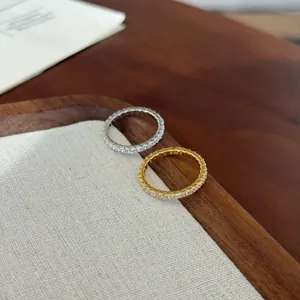 Detailed close-up of S925 sterling silver and gold eternity rings with sparkling clear stones