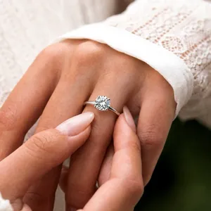 Elegant solitaire moissanite S925 sterling silver engagement ring detail on finger.