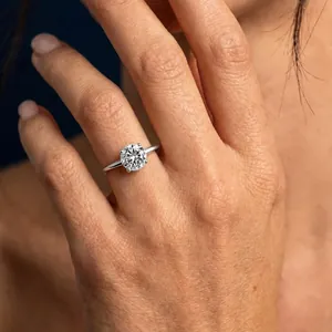 Close-up detail of a sparkling moissanite solitaire engagement ring on a female hand
