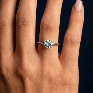 Detailed close-up showing a sparkling classic four-prong moissanite solitaire ring on hand