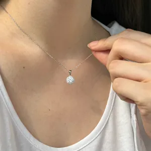 Gros plan montrant le pendentif rond étincelant en moissanite sur une chaîne en argent