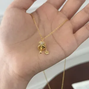 Detailed view of S925 sterling silver gold prayer wheel pendant necklace held in hand