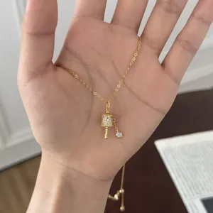 Detailed view of an exquisite gold Tibetan prayer wheel necklace pendant with sparkling crystals