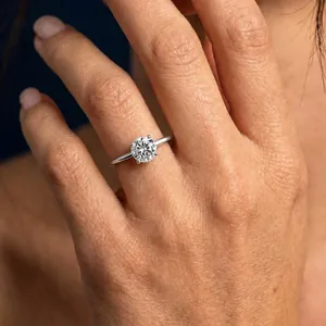 Elegant S925 sterling silver solitaire moissanite ring with four-prong setting worn on finger