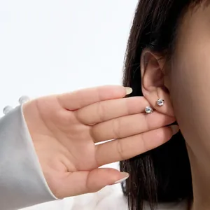Gros plan sur les boucles d'oreilles solitaires en argent 925 avec diamants ronds