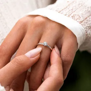 Elegant close-up of a sterling silver moissanite solitaire ring worn on a woman's hand