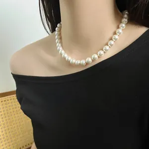 Elegant white pearl necklace worn on neck featuring large round lustrous high-quality beads.