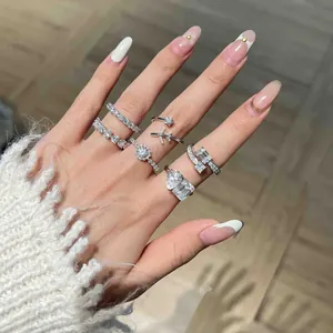 Detailed view of multiple moissanite rings on a hand including heart and emerald cuts
