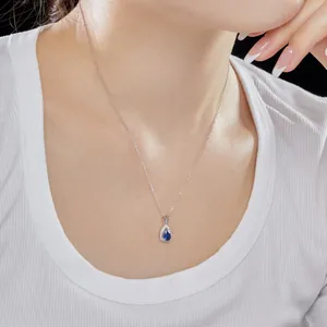 Vue détaillée d'un collier en argent s925 avec pendentif goutte bleue porté délicatement au cou