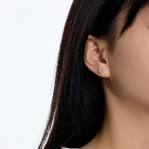 Gros plan d'une boucle d'oreille cœur en argent 925 sur l'oreille d'un mannequin