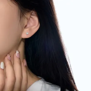 Détail d'une boucle d'oreille en argent 925 en forme de cœur étincelant sur mannequin