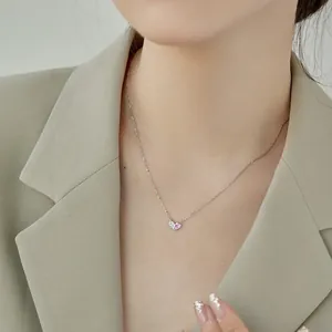 Élégant collier en argent avec pendentif cœur en zircons roses et clairs sur un modèle