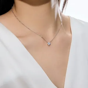 Gros plan d'un collier avec un seul diamant en forme de cœur sur le cou d'un modèle
