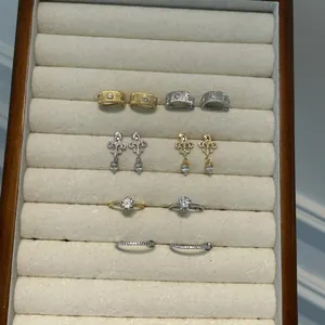 Detailed view of S925 sterling silver Fleur-de-lis earrings and diamond rings